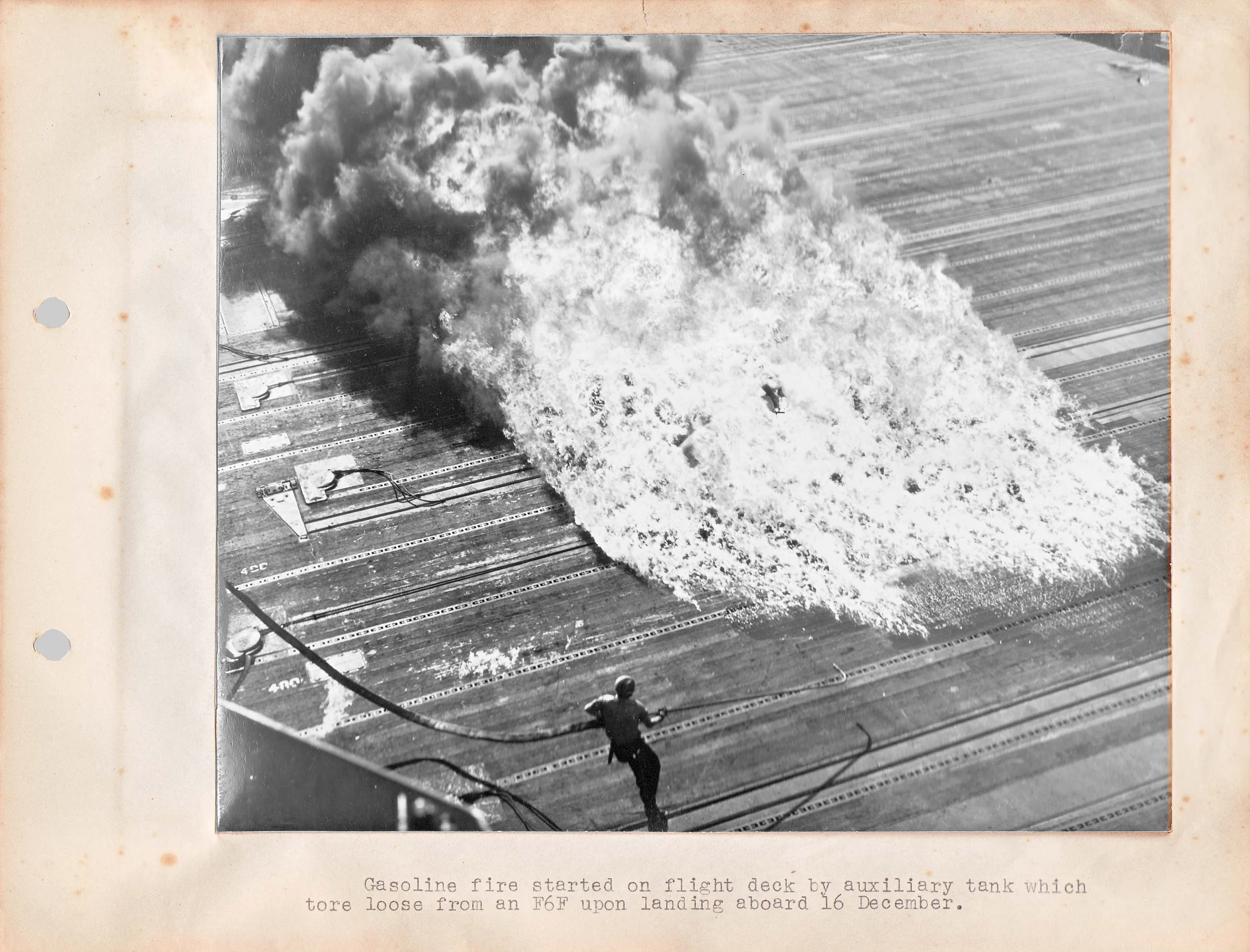 A fire on the Essex flight deck after a belly tank breaks away from an F6F Hellcat after land...webp