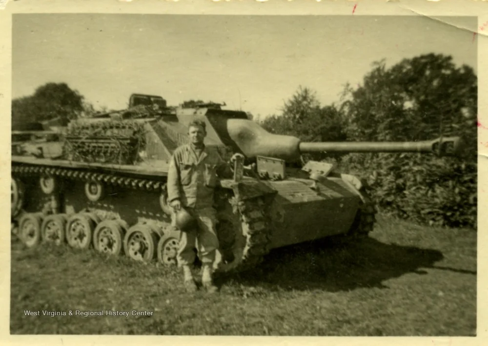 American Soldier poses with captured German AFV.webp