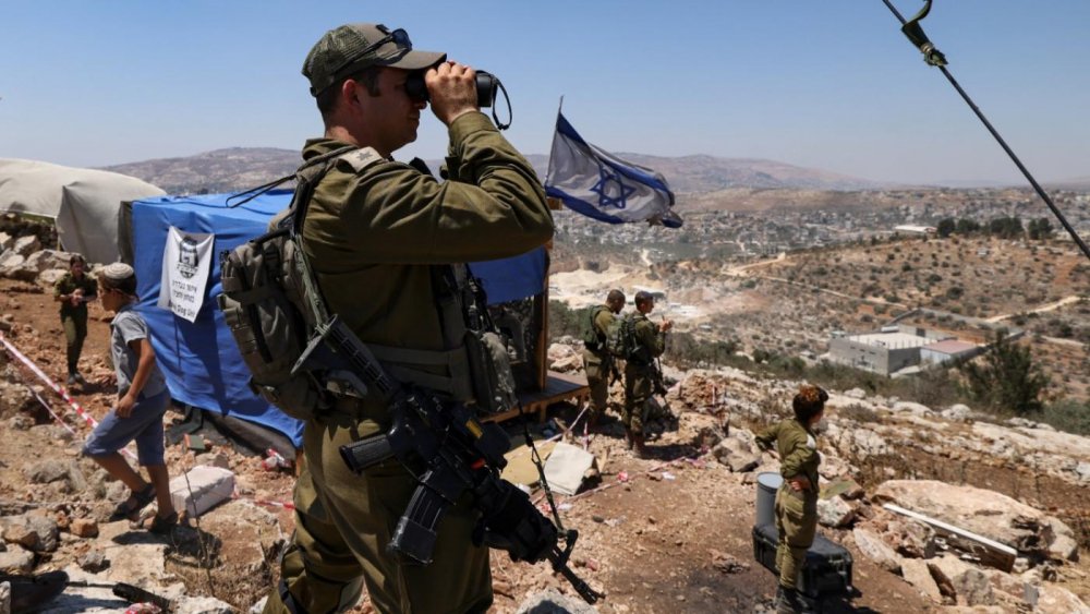 Israeli soldiers observe the Palestinian village of Beita with binoculars as settlers evacuate...jpg