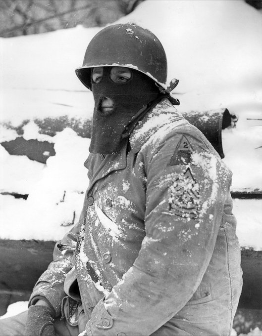 Sgt. Wadsworth, US 2nd Armored Division, wears a mask which he has made from an army-issue sca...jpg