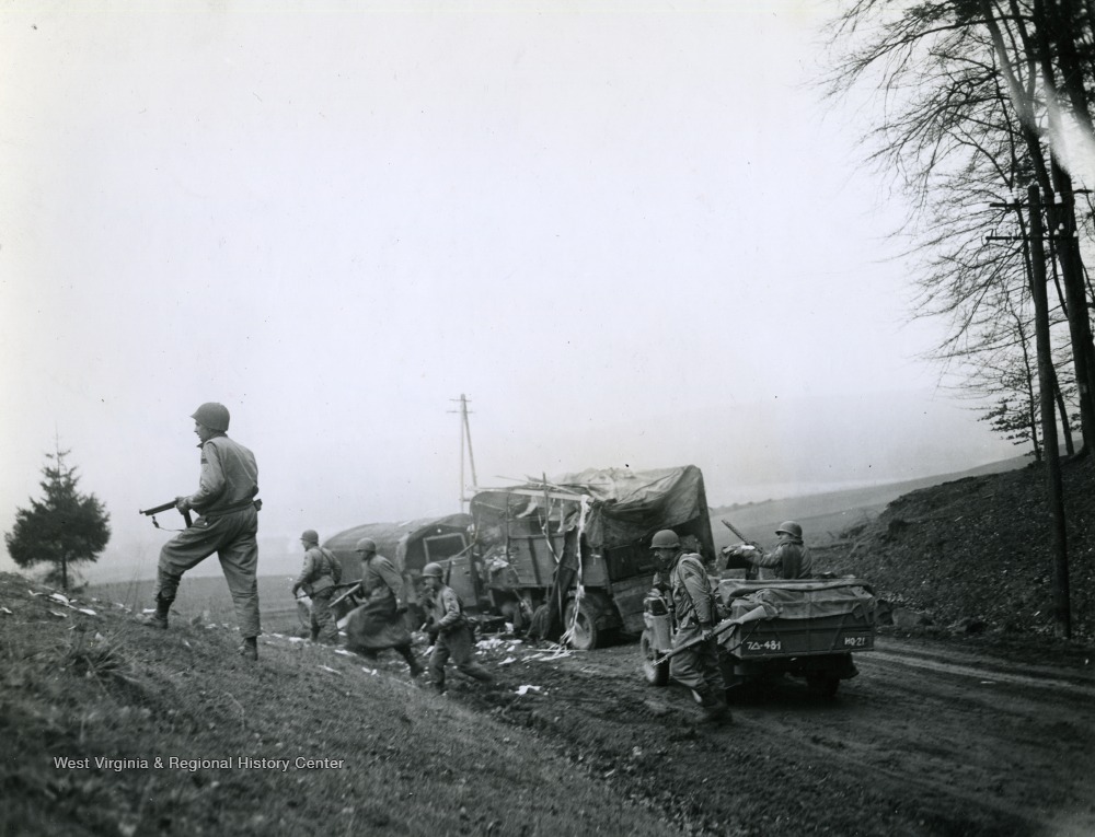TSMG 7th Armrd Div soldiers check out area around destroyed German vehicles.jpg