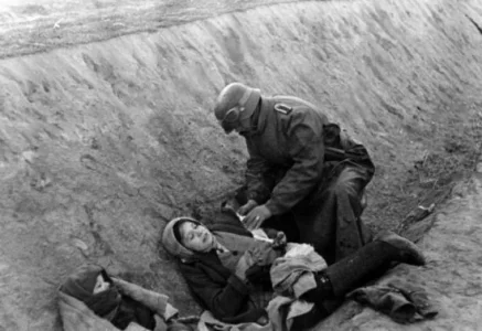 A German soldier applies a dressing to a wounded Russian civilian, 1941.webp