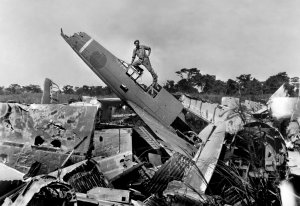  авиатор Джон Хартье позирует у разбитых японских самолётов на аэродроме Кларк Филд на Филиппи...jpg