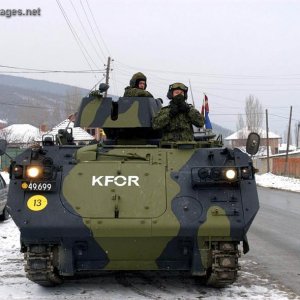Danish vehicle patrolling village around Mitrovica