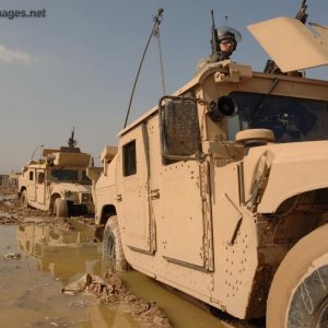 Soldiers maneuver their Humvees through the mud