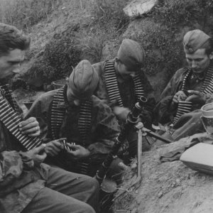 Four SS soldiers with ammunition belts in a trench near Leningrad (1942)