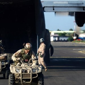Air Force pararescuemen off load quads off a C-130