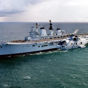 Merlin helicopter flying past HMS Ark Royal