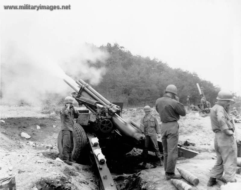 Gun crew fires a 155-mm  howitzer