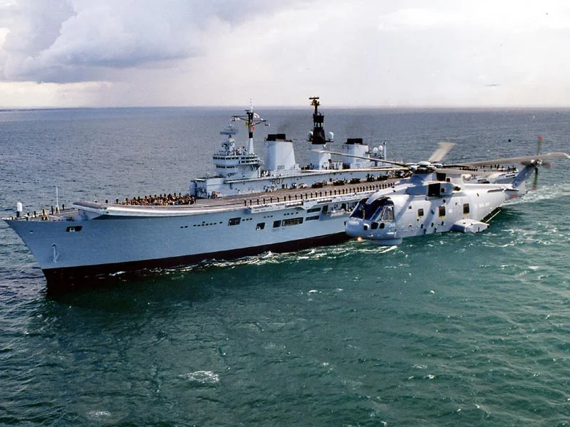 Merlin helicopter flying past HMS Ark Royal